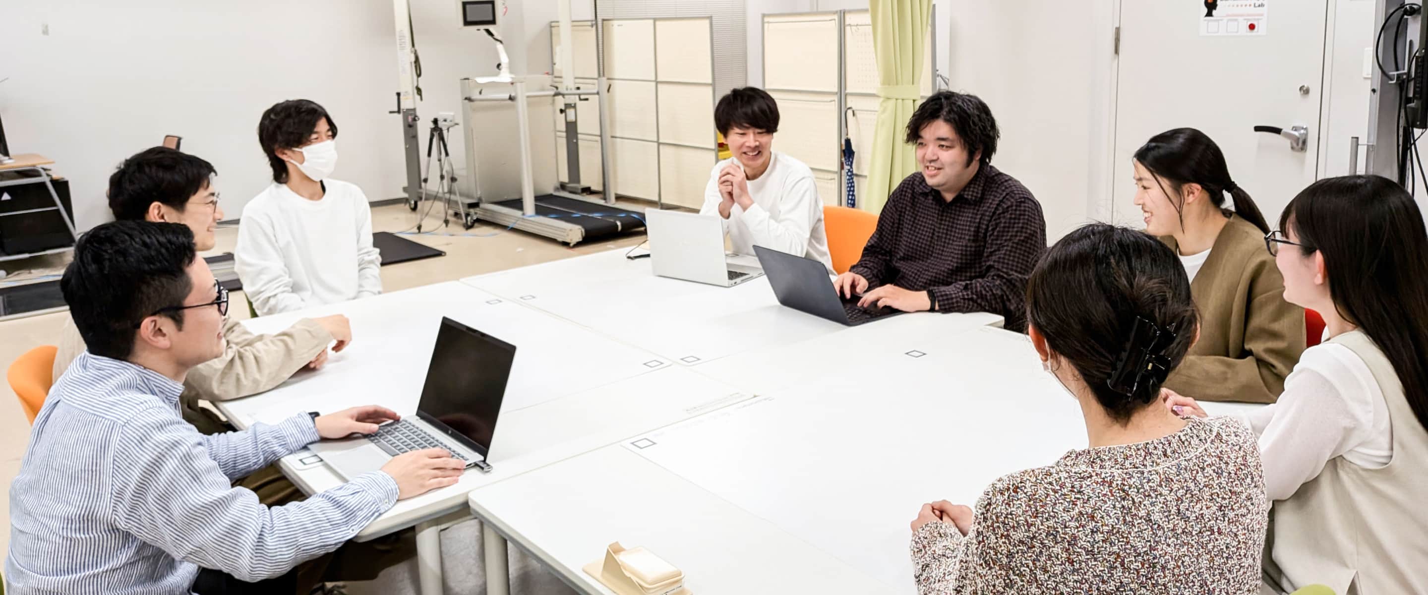 研究室のメンバーで話し合っている写真